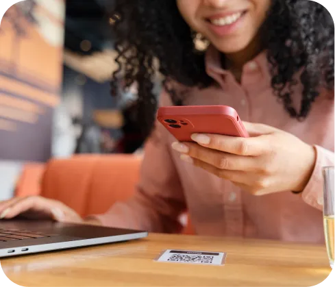 Mujer emprendedor sonriente usando celular para scanear un QR para  pagos en Poket