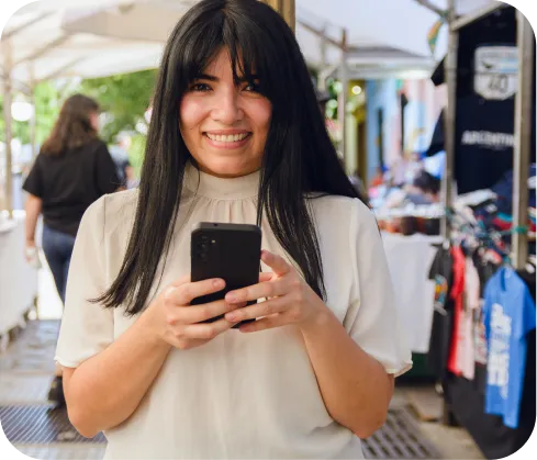 Mujer emprendedora sonriente usando celular para cobrar con Poket
